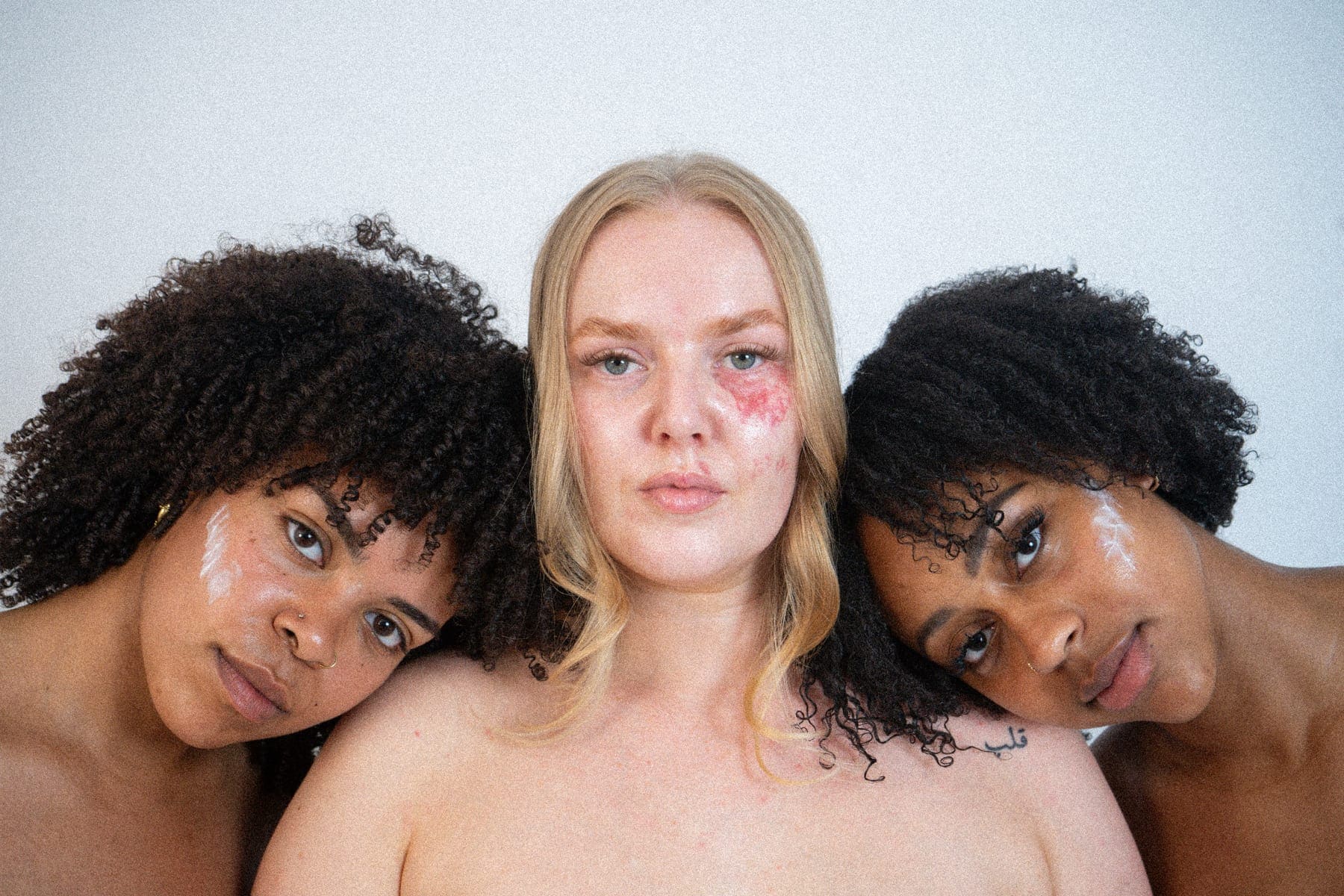 Three women with different skin tones and skin types side by side