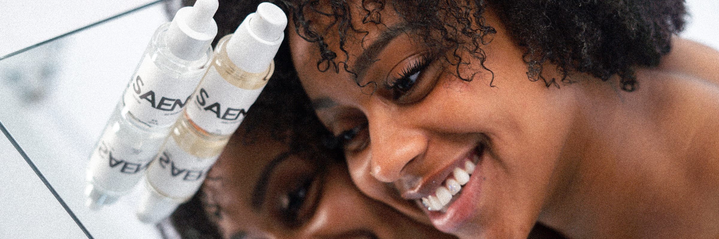 Saene serums beside a smiling face